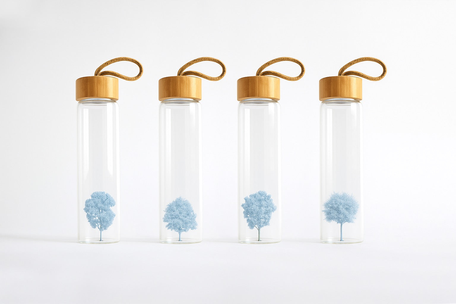 Four glass Agua bottles with miniature trees inside