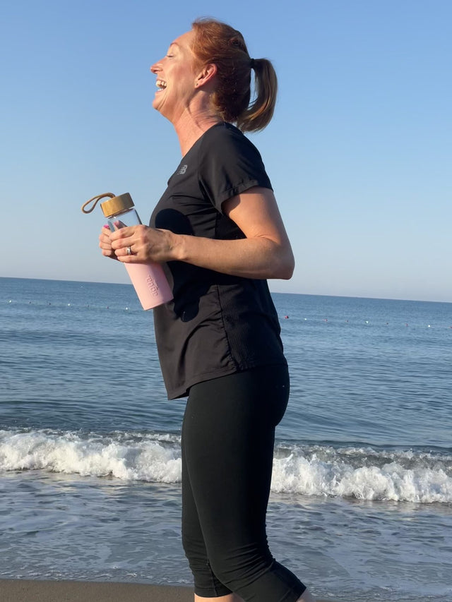 Pink bottle beside the sea